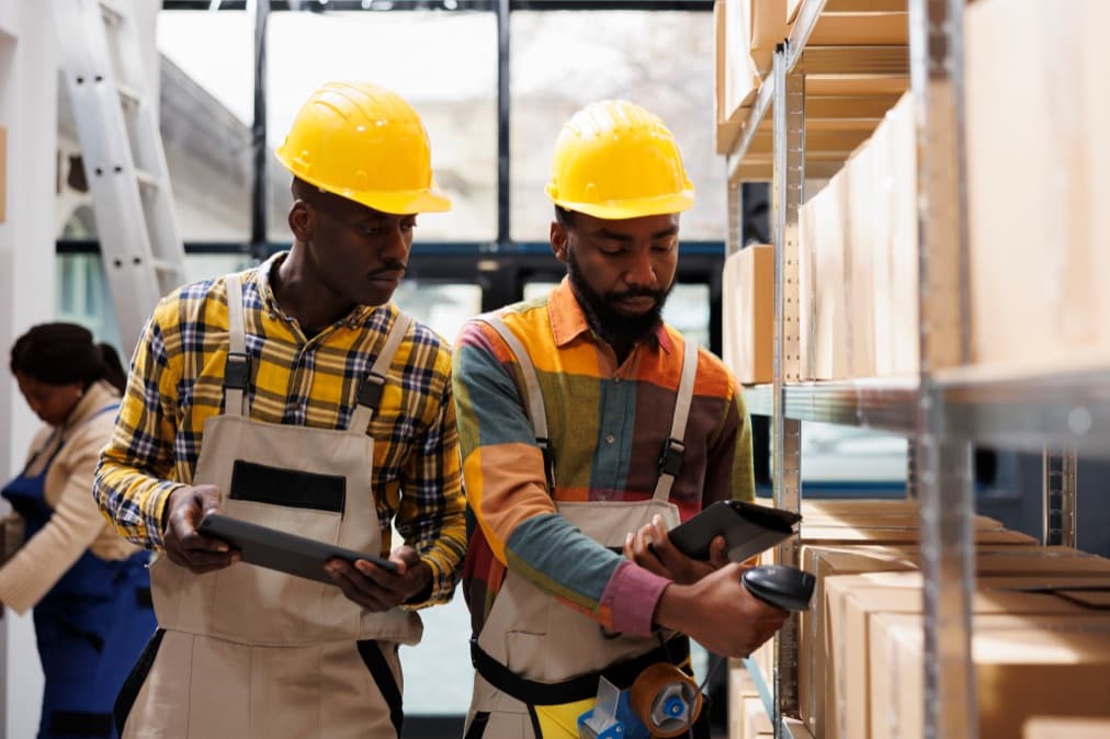 Customs workers reviewing documents at a warehouse